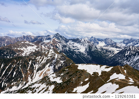 Panoramic view of snow-capped mountain range against cloudy sky. Tatra mountains in Zakopane, Poland. Giewont mountain summit. Natural landscape Panoramic view of snow-capped mountain range against cloudy sky. Tatra mountains in Zakopane, Poland. Giewont mountain summit. Natural landscape 119263381
