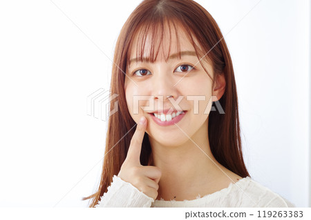 A woman pointing at her mouth with a smile 119263383