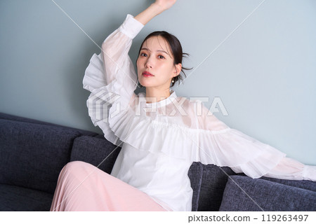 一個女人坐在沙發上 119263497