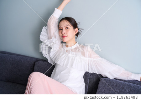A woman sitting on a sofa A woman sitting on a sofa 119263498