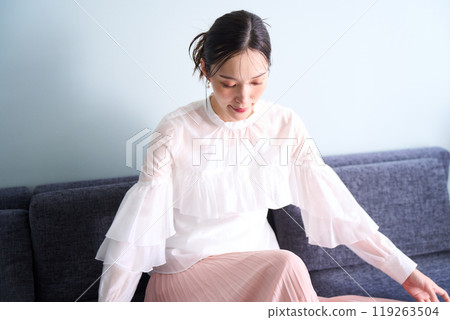 A woman sitting on a sofa A woman sitting on a sofa 119263504
