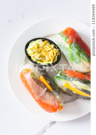 Savor the authentic taste of Vietnamese spring rolls with rice paper, fresh vegetables, salmon, and fish sauce, blending the best of Asian and Thai cuisine in a healthy 119264489