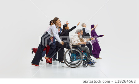 Diverse group of individuals, including one in wheelchair, all energetically reaching forward in motion against white studio background. Diverse group of individuals, including one in wheelchair, all energetically reaching forward in motion against white studio background. 119264568