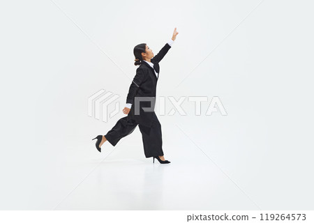 Businesswoman energetically running while reaching forward as if to achieve goal against white studio background. Businesswoman energetically running while reaching forward as if to achieve goal against white studio background. 119264573