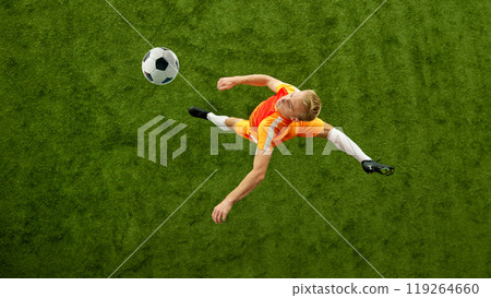 Young football athlete posing exudes readiness to control next move in this competitive football match on green grass of football field. Aerial view. Young football athlete posing exudes readiness to control next move in this competitive football match on green grass of football field. Aerial view. 119264660