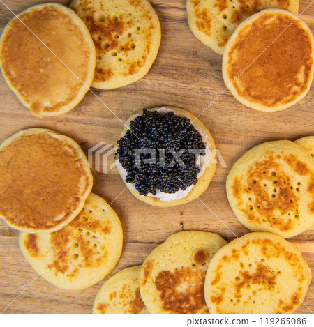 Blinis with black caviar and cream cheese, on a festive dish, mini pancakes, an elegant appetizer Blinis with black caviar and cream cheese, on a festive dish, mini pancakes, an elegant appetizer 119265086