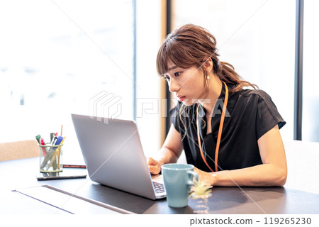 一位女士在工作時眼睛靠近電腦螢幕 119265230