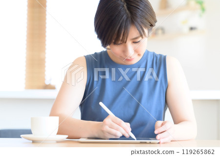 A woman using a touch pen to operate a tablet device A woman using a touch pen to operate a tablet device 119265862