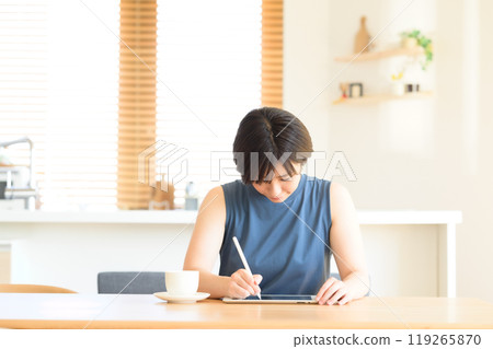 一位女士手持觸控筆操作平板電腦設備 一位女士手持觸控筆操作平板電腦設備 119265870