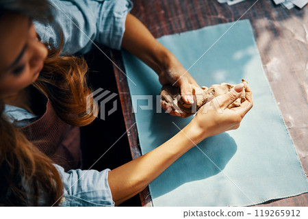 Female potter sculpts from clay at her workshop 119265912