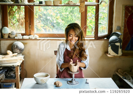 Female artist sculpts crafts with ceramic clay at her creative workshop 119265920