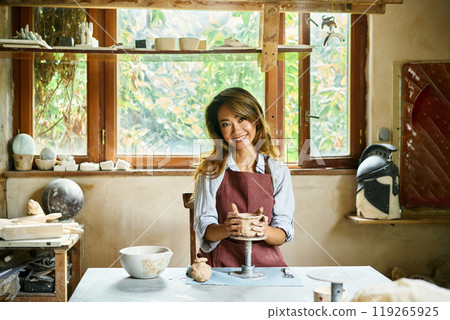 Female artist sculpts crafts with ceramic clay at her creative workshop 119265925