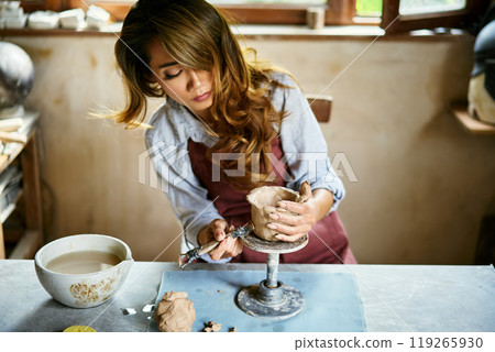 Female artist sculpts crafts with ceramic clay at her creative workshop Female artist sculpts crafts with ceramic clay at her creative workshop 119265930