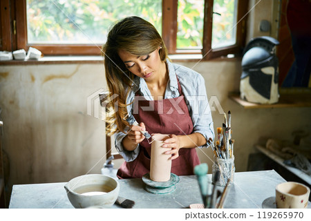 Female artist sculpts crafts with ceramic clay at her creative workshop 119265970