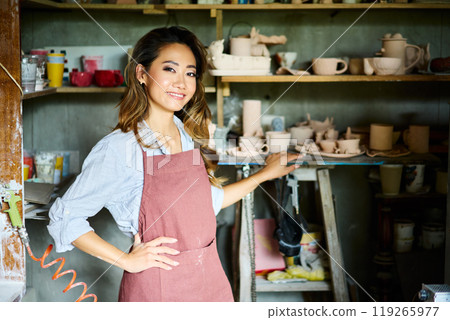 Female artist placing her ceramic clay crafts at pottery kiln 119265977