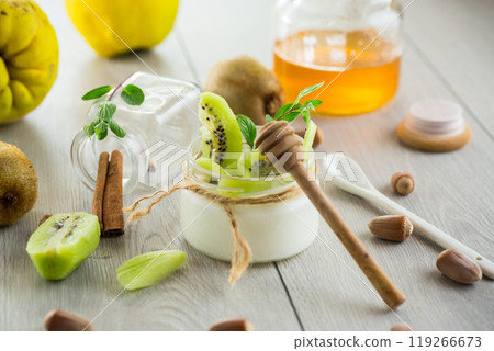 Homemade yogurt in a glass jar with honey, kiwi, nuts. 119266673