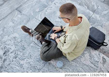 Top view of unrecognizable male IT developer code programming on laptop while sitting on concrete steps working outside in city, copy space 119267458