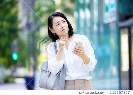 在戶外拿著智慧型手機有困難的女商人 119267567