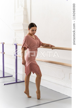 Woman rehearsing ballet choreography in studio exercising graceful movements at barre Woman rehearsing ballet choreography in studio exercising graceful movements at barre 119268080