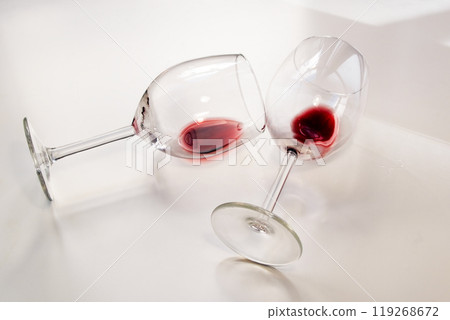 Two half empty glasses glasses of red wine on a white background 119268672