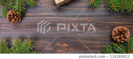 Christmas background with fir tree and gift box on wooden table. Top view with copy space for your design Christmas background with fir tree and gift box on wooden table. Top view with copy space for your design 119269012