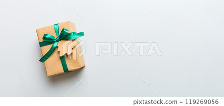 wrapped christmas or other holiday handmade present in paper with colored ribbon. Present box, decoration of gift on colourfull table, top view with copy space wrapped christmas or other holiday handmade present in paper with colored ribbon. Present box, decoration of gift on colourfull table, top view with copy space 119269056