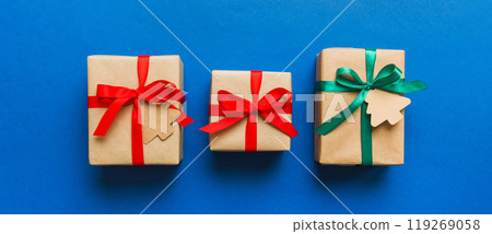 wrapped christmas or other holiday handmade present in paper with colored ribbon. Present box, decoration of gift on colourfull table, top view with copy space wrapped christmas or other holiday handmade present in paper with colored ribbon. Present box, decoration of gift on colourfull table, top view with copy space 119269058