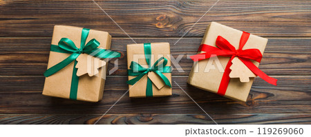 wrapped christmas or other holiday handmade present in paper with colored ribbon. Present box, decoration of gift on colourfull table, top view with copy space 119269060