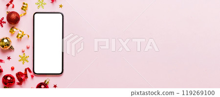 Christmas online shopping from home phone with blank white display top view. smart mobile with copy space on colored background with Christmas decorations balls,. Winter holidays sales background Christmas online shopping from home phone with blank white display top view. smart mobile with copy space on colored background with Christmas decorations balls,. Winter holidays sales background 119269100