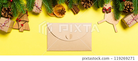 Top view of envelope on yellow background. New Year decorations. Christmas holiday concept 119269271