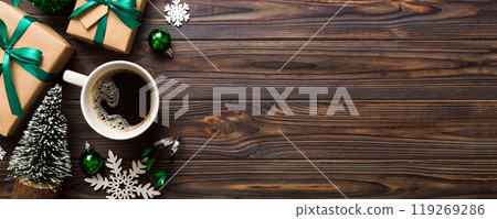 Delicious fresh festive morning coffee in a ceramic cup with little wrapped gifts, ornament and xmas toy. Cup of coffee and new year toys Delicious fresh festive morning coffee in a ceramic cup with little wrapped gifts, ornament and xmas toy. Cup of coffee and new year toys 119269286