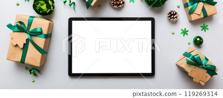 Top view of empty tablet on Christmas background made of new year decorand festive decorations. New year holiday concept. Mockup 119269314