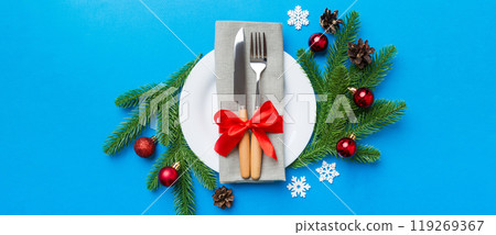 Christmas table place setting with christmas decor and plates, kine, fork and spoon. Christmas holiday background. Top view Christmas table place setting with christmas decor and plates, kine, fork and spoon. Christmas holiday background. Top view 119269367