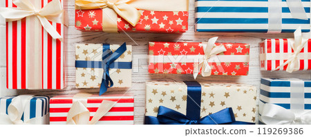 A lot of Christmas gift boxes in colored paper decorated on table, Top view close up. Many present New Year gift A lot of Christmas gift boxes in colored paper decorated on table, Top view close up. Many present New Year gift 119269386