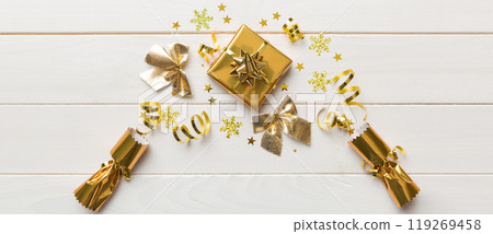 Christmas crackers with shiny confetti on color background, top view, copy space Christmas crackers with shiny confetti on color background, top view, copy space 119269458