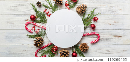Flat lay Christmas composition. Round Paper blank, pine tree branches, christmas decorations on Colored background. Top view, copy space for text Flat lay Christmas composition. Round Paper blank, pine tree branches, christmas decorations on Colored background. Top view, copy space for text 119269465