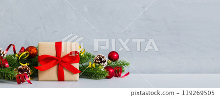 New Year Christmas mood, gift box, branches of a christmas tree, New Year decorations on a colored background 119269505