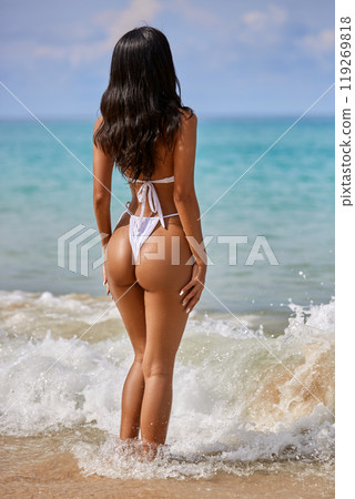 Beautiful asian girl in white bikini posing at the tropical beach, back view 119269818