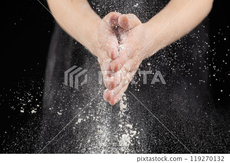 Splash of wheat flour, cook working with dough, hands close-up. 119270132