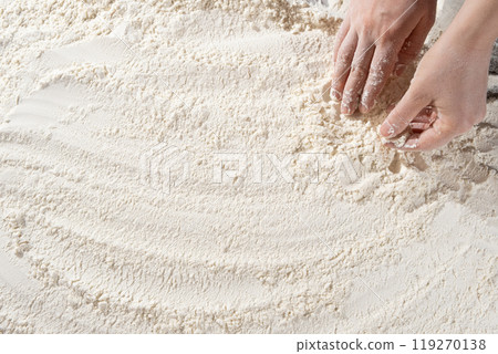 Baker working with white wheat flour, hands close-up. 119270138