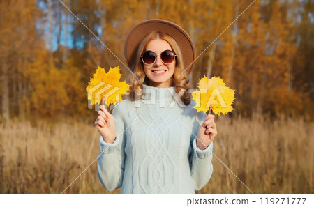 Autumn portrait of stylish happy young woman with yellow leaves, girl smiling outdoors in park Autumn portrait of stylish happy young woman with yellow leaves, girl smiling outdoors in park 119271777
