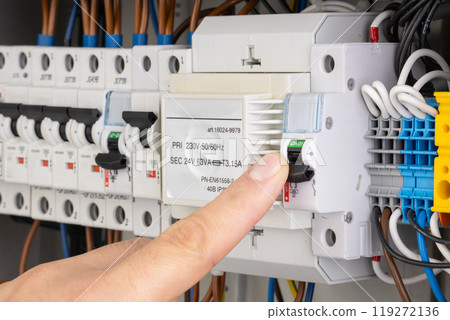 Finger Switching Off Circuit Breaker in Electrical Panel 119272136