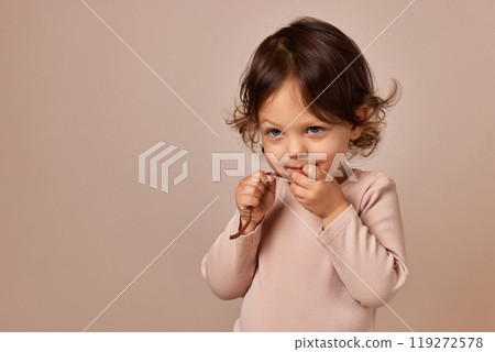 happy child girl holding fruit pastille on beige background. healthy baby food. happy child girl holding fruit pastille on beige background. healthy baby food. 119272578