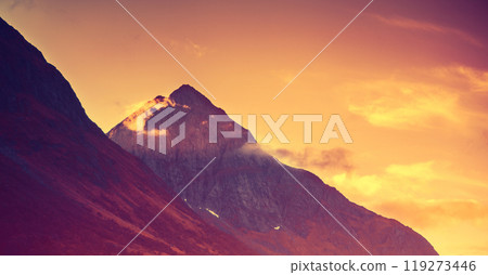 Dramatic evening cloudy sky over mountains peaks. Sunset over the mountains Dramatic evening cloudy sky over mountains peaks. Sunset over the mountains 119273446