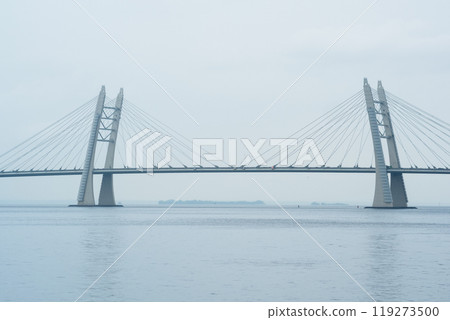 distant bridge over foggy bay on rainy day 119273500