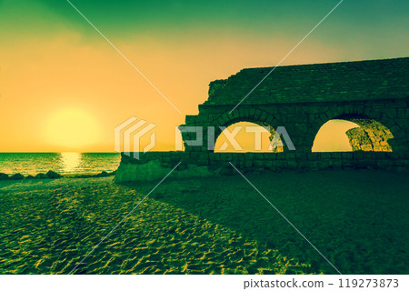 Remains of the ancient Roman aqueduct in ancient city Caesarea at sunset. Israel. Remains of the ancient Roman aqueduct in ancient city Caesarea at sunset. Israel. 119273873