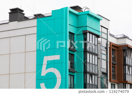 High-rise residential building with a striking turquoise facade in an urban area emphasizing rental 119274079