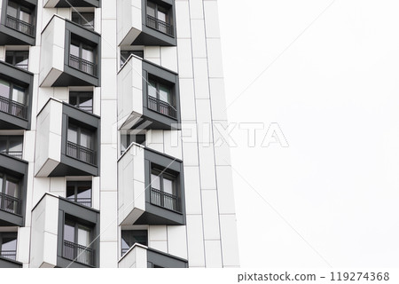 Modern high-rise apartment buildings with distinctive balconies in a residential area showcasing 119274368
