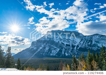 Banff National Park beautiful landscape. Mount Rundle mountain valley with green and yellow color trees forest in snowy autumn sunny day. Canadian Rockies. 119274406