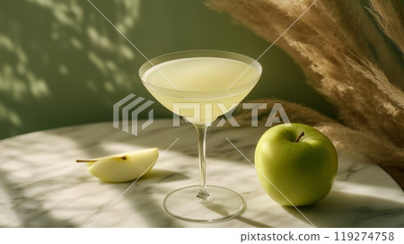 A green apple martini in an elegant glass with a green apple slice beside it. 119274758